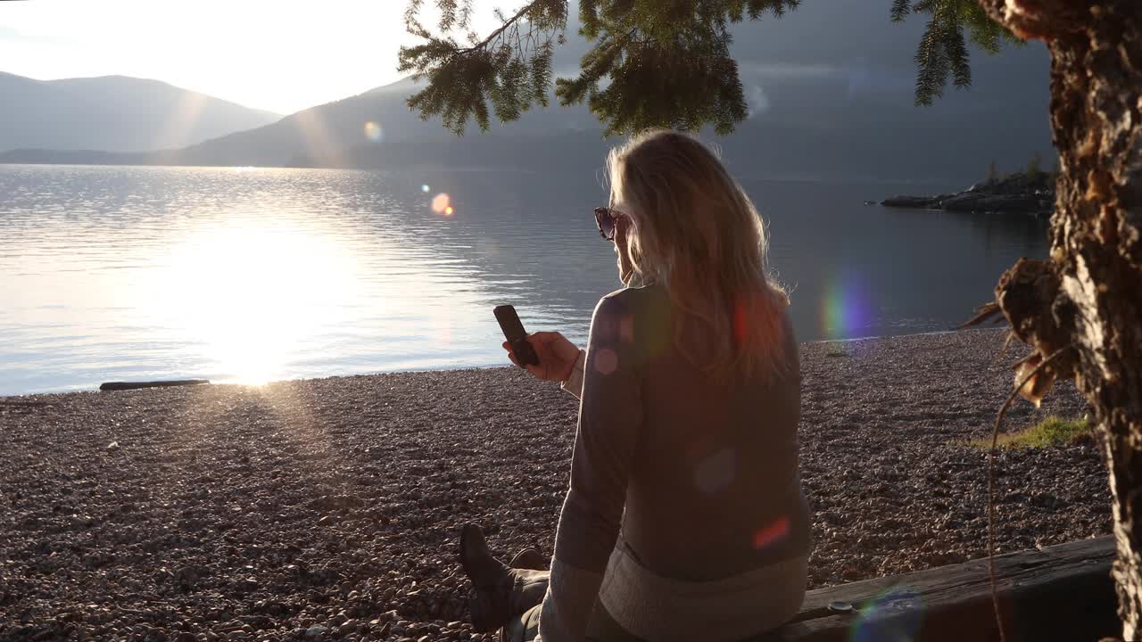 一对夫妇在山湖边的海滩上放松视频素材
