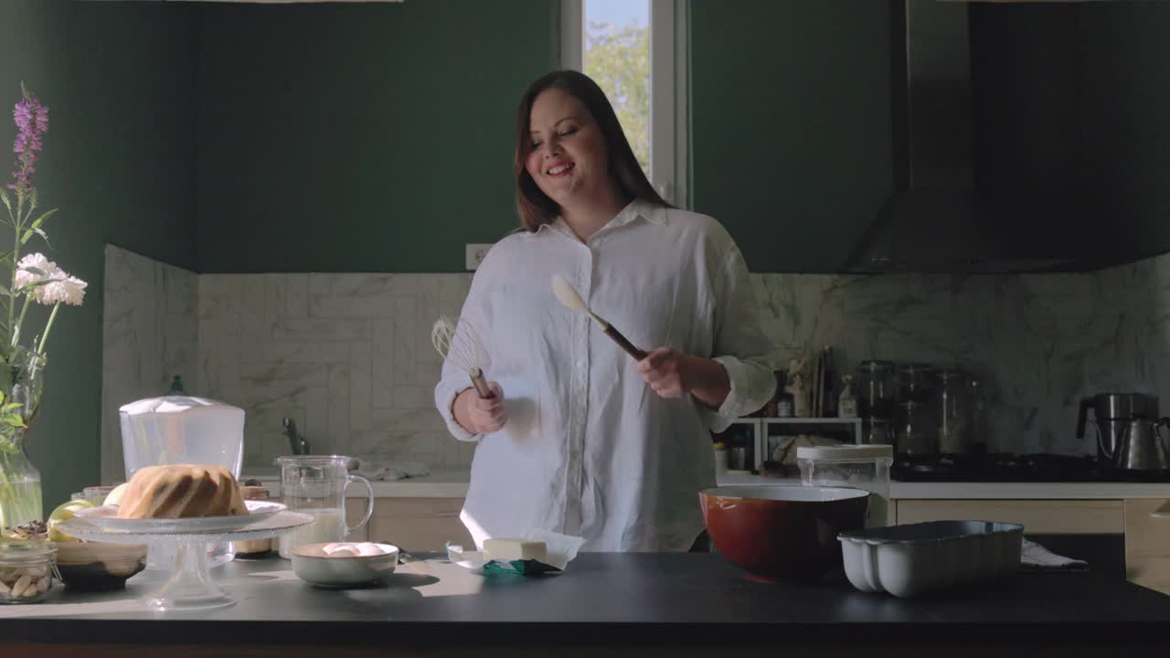 快乐超重的女面包师在厨房里一边做面团一边跳舞视频下载