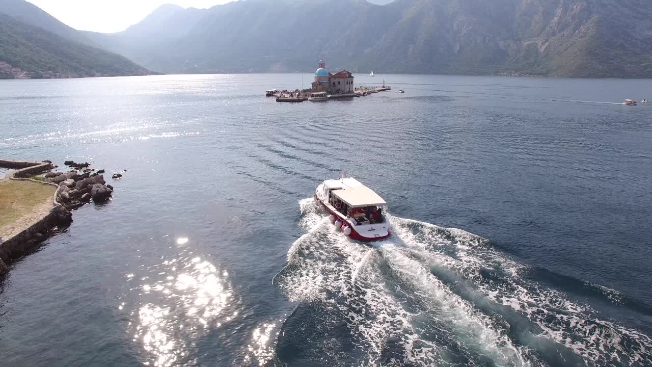 一艘观光船沿着科托尔湾航行，经过圣乔治岛前往戈斯帕岛视频素材