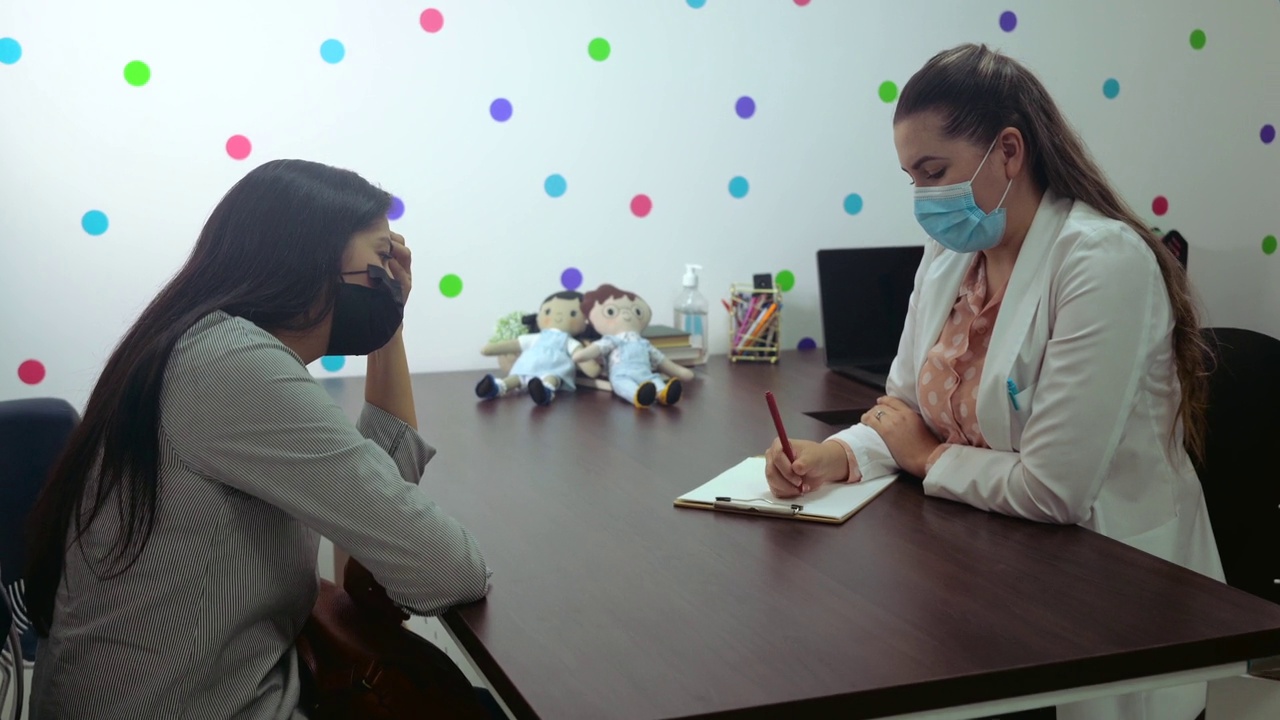 戴着面具的女心理学家与病人交谈并做笔记视频下载