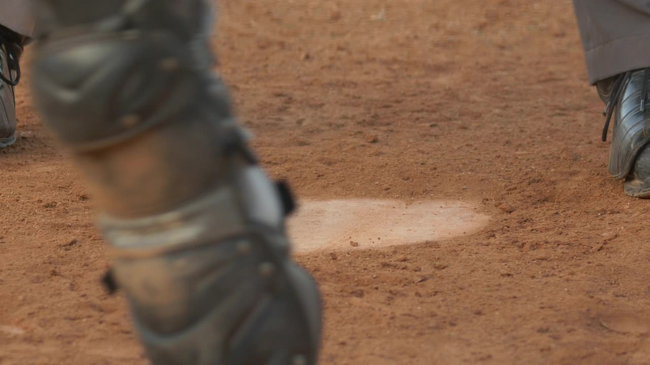 棒球裁判在一场比赛中把本垒踢掉。——慢动作视频下载