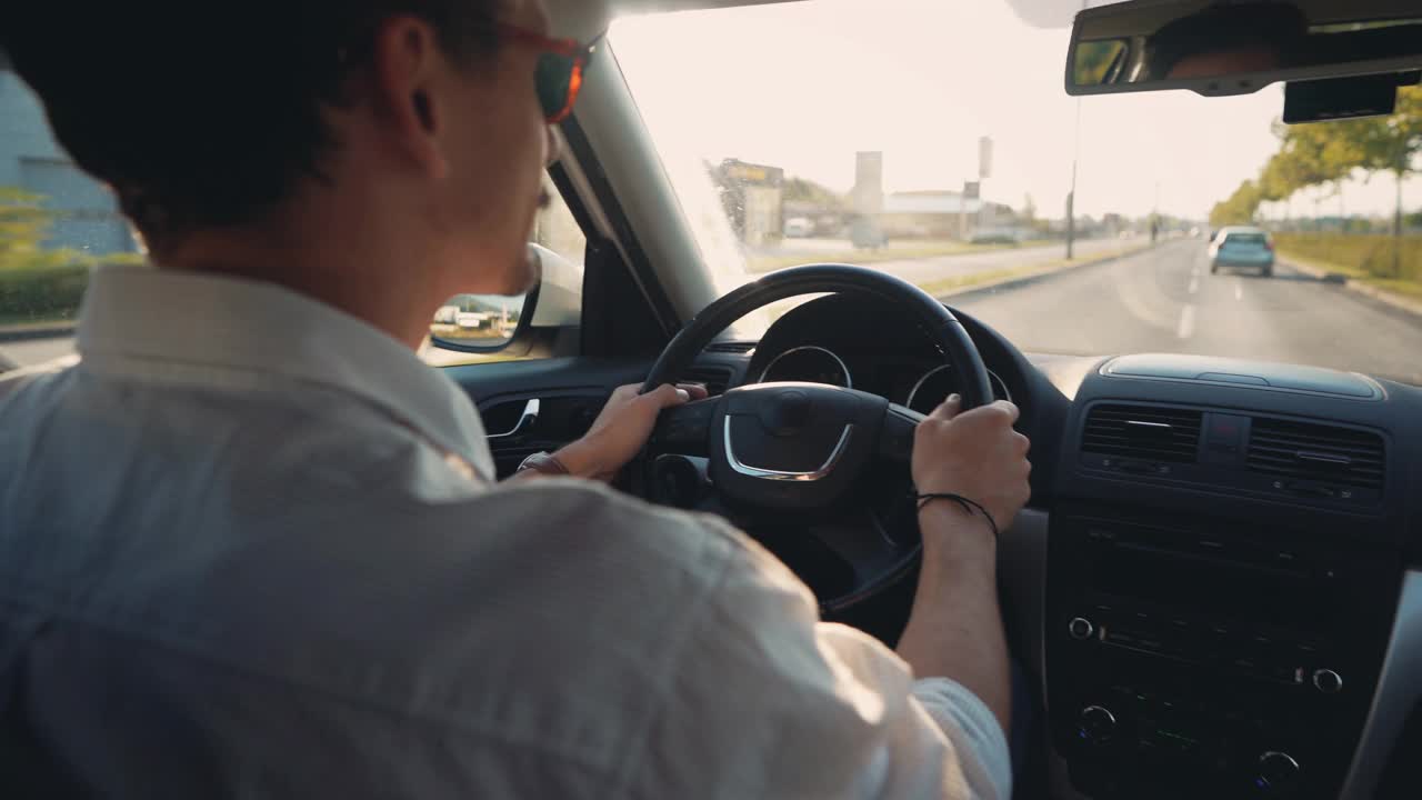 一个无忧无虑的年轻人的B-roll，驾驶着汽车穿过城市视频下载