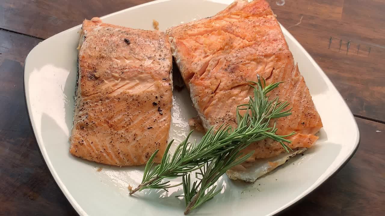 烧烤鲑鱼从木炭烧烤外面为晚餐镀在白色盘子装饰视频下载