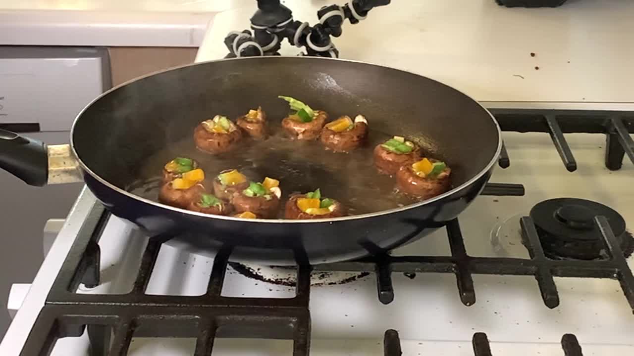 烹饪在煤气炉上的黑色煎锅中准备的墨西哥胡椒和奶酪蘑菇视频下载