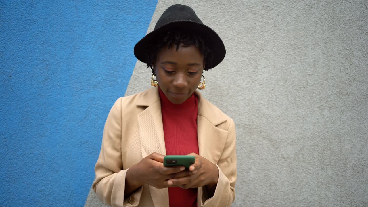 年轻时尚的黑人女性在墙上摆姿势视频下载