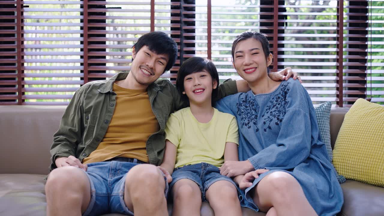 快乐的亚洲家庭在客厅的沙发上共度时光的肖像。家庭和家的概念。视频素材