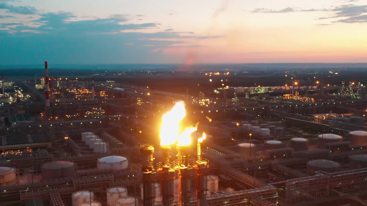 炼油厂的火炬烟囱在晚上释放火焰视频素材