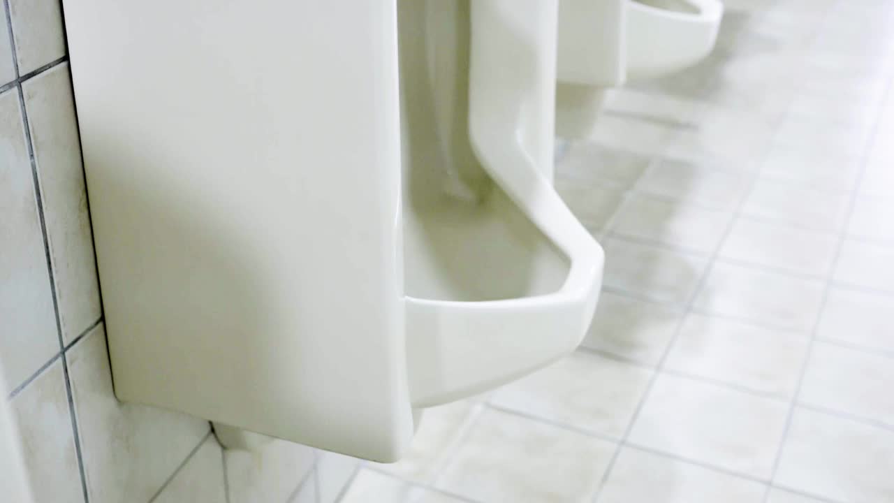 一座现代化建筑中的男厕所。从下往上倾斜射击。厕所的外观很干净。视频下载