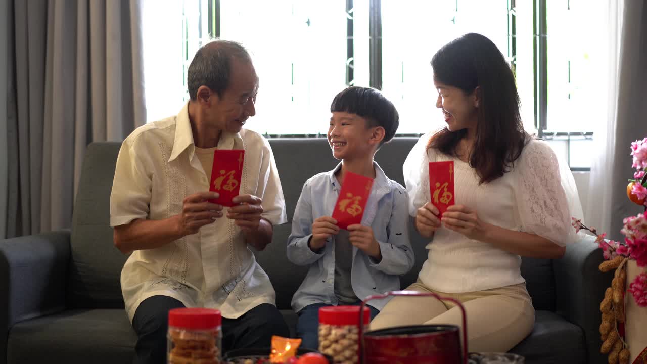 三代亚洲华人家庭在客厅里拿着红包视频素材