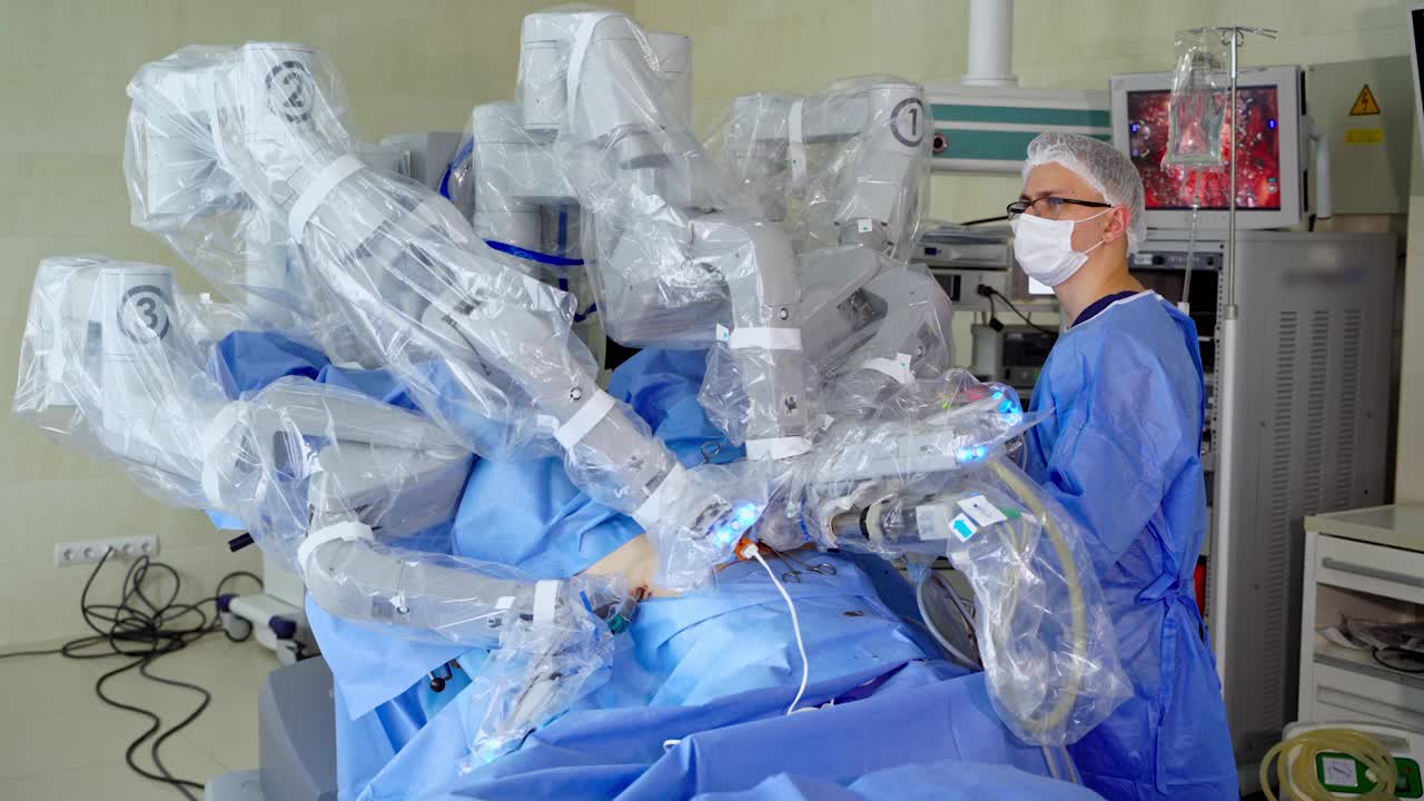 外科手术用高科技设备。手术机器人为病人进行微创手术。医院里穿着医疗制服的专业外科医生在机器人旁边。视频素材