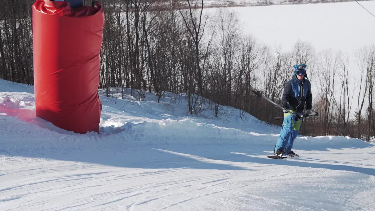 在一个阳光明媚的日子里，一名滑雪者在滑雪胜地使用t型升降机爬上一座山视频素材
