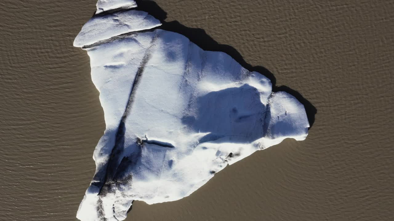 无人机视频上升，同时俯瞰在冰川融水漂浮的v形冰山，冰岛视频下载