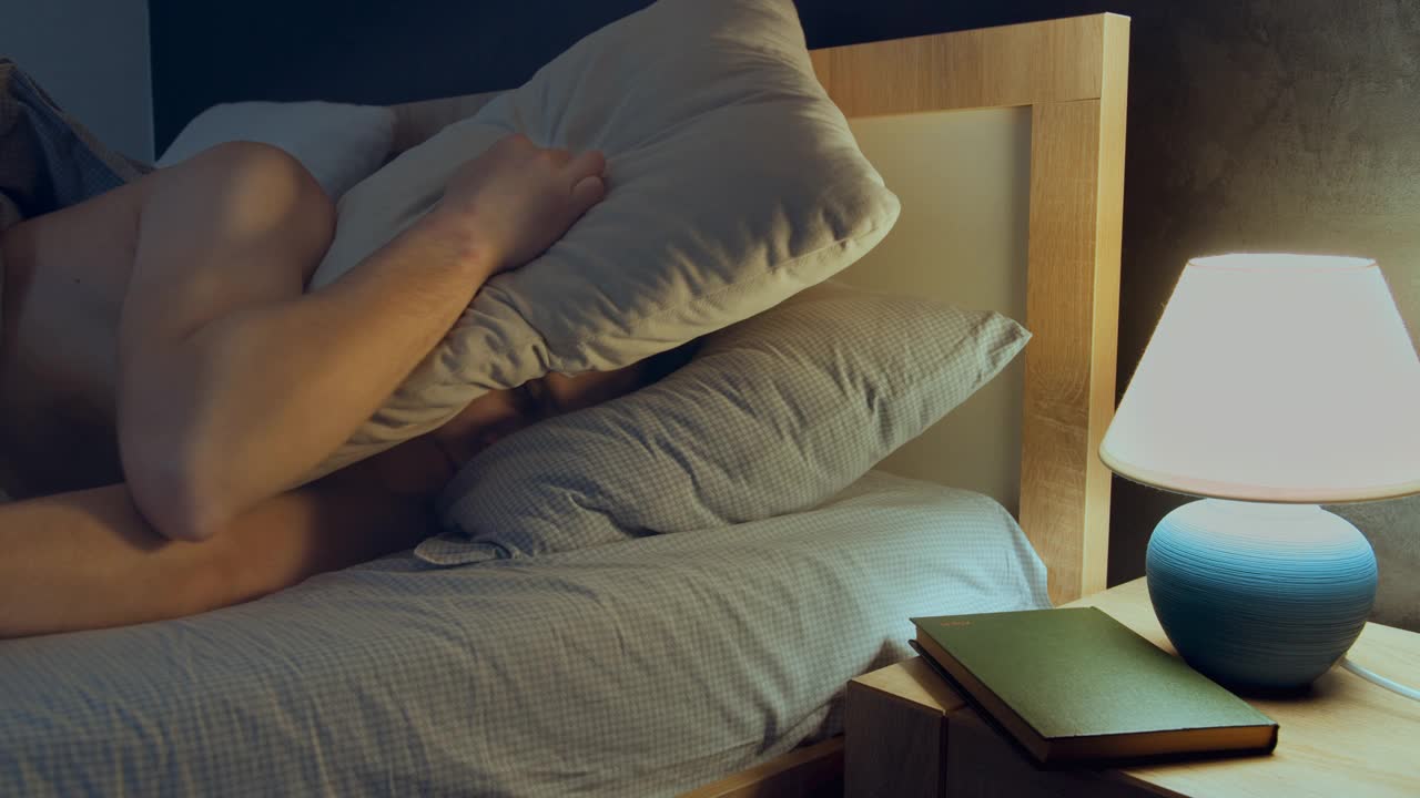 人们晚上躺在床上睡不着，用枕头蒙住头视频下载