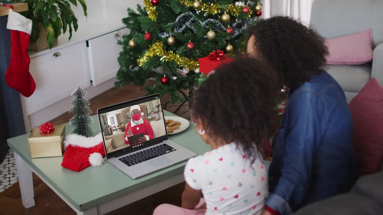 快乐的非洲裔美国母亲和女儿在圣诞节与戴面具的圣诞老人视频通话视频下载