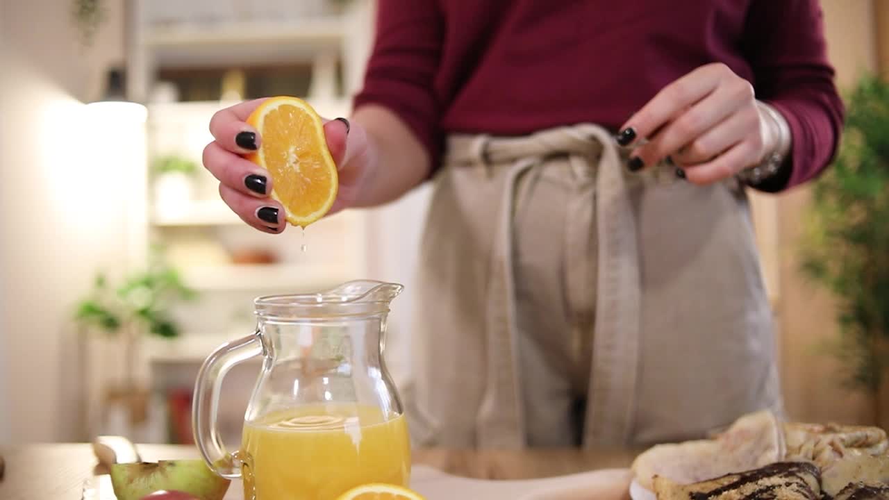 一个女人准备新鲜的果汁，健康的生活方式。视频下载