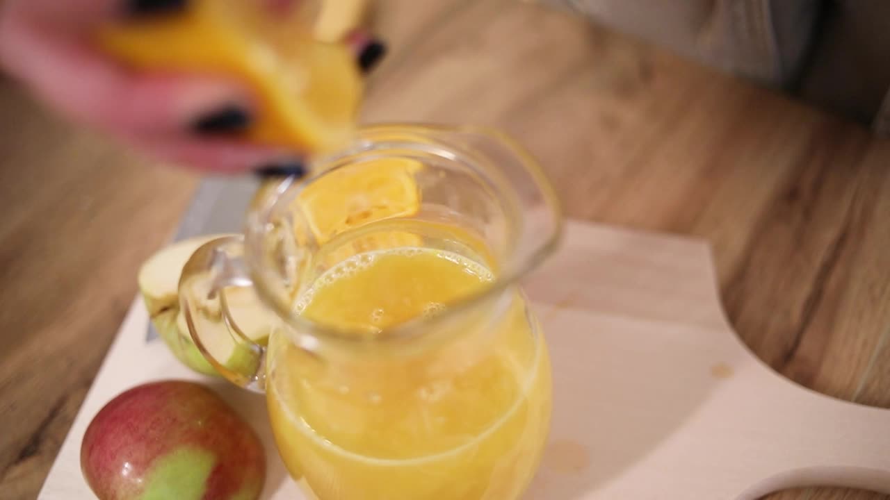 一个女人准备新鲜的果汁，健康的生活方式。视频下载