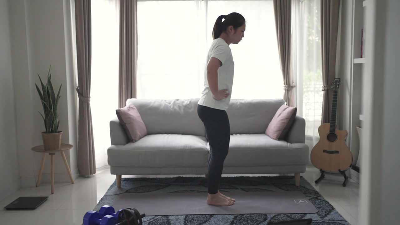 女性在家锻炼和练习用平板电脑燃烧脂肪视频下载