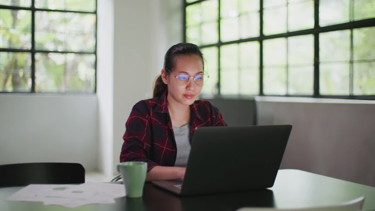 亚洲女性使用笔记本电脑在家工作视频素材