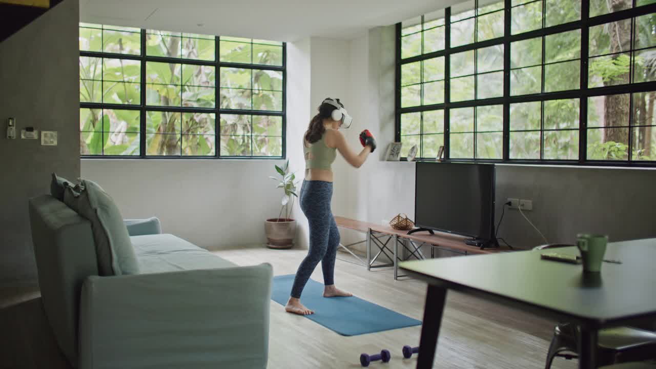 体育女子拳击在虚拟现实头盔训练踢在家里虚拟现实视频下载