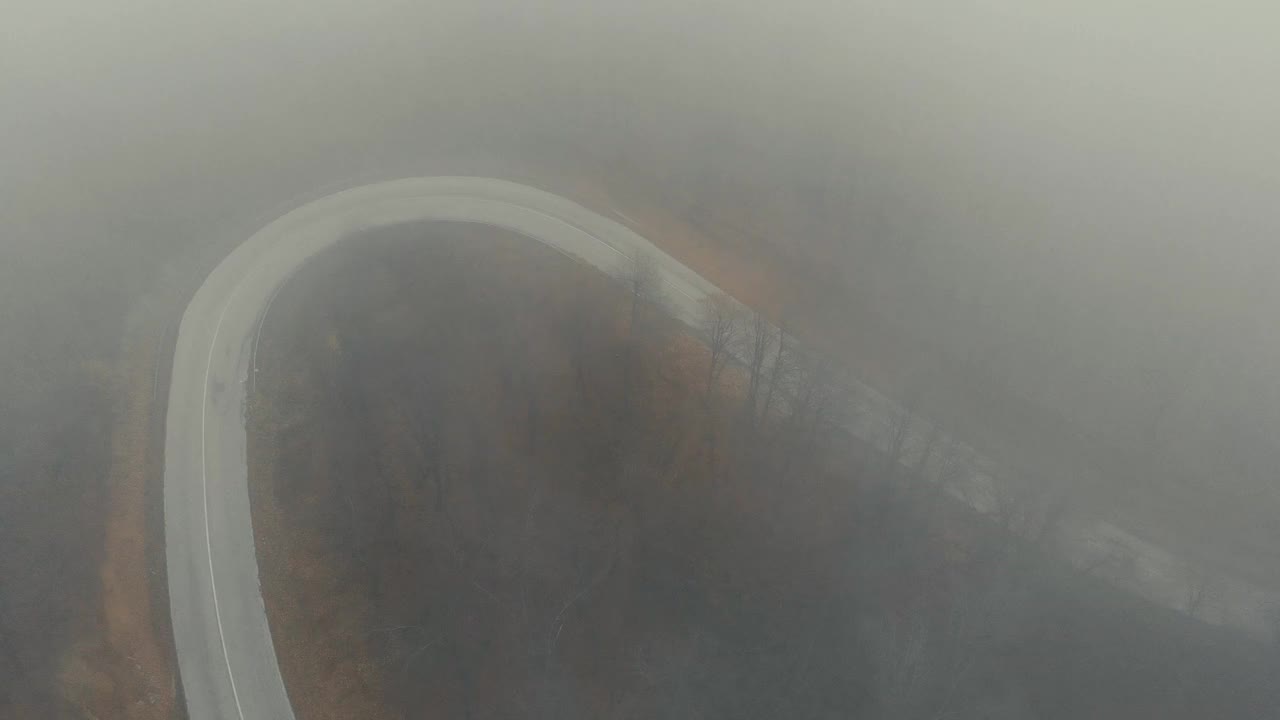 汽车在浓雾笼罩的山路上行驶。自然美丽的秋天。视频素材