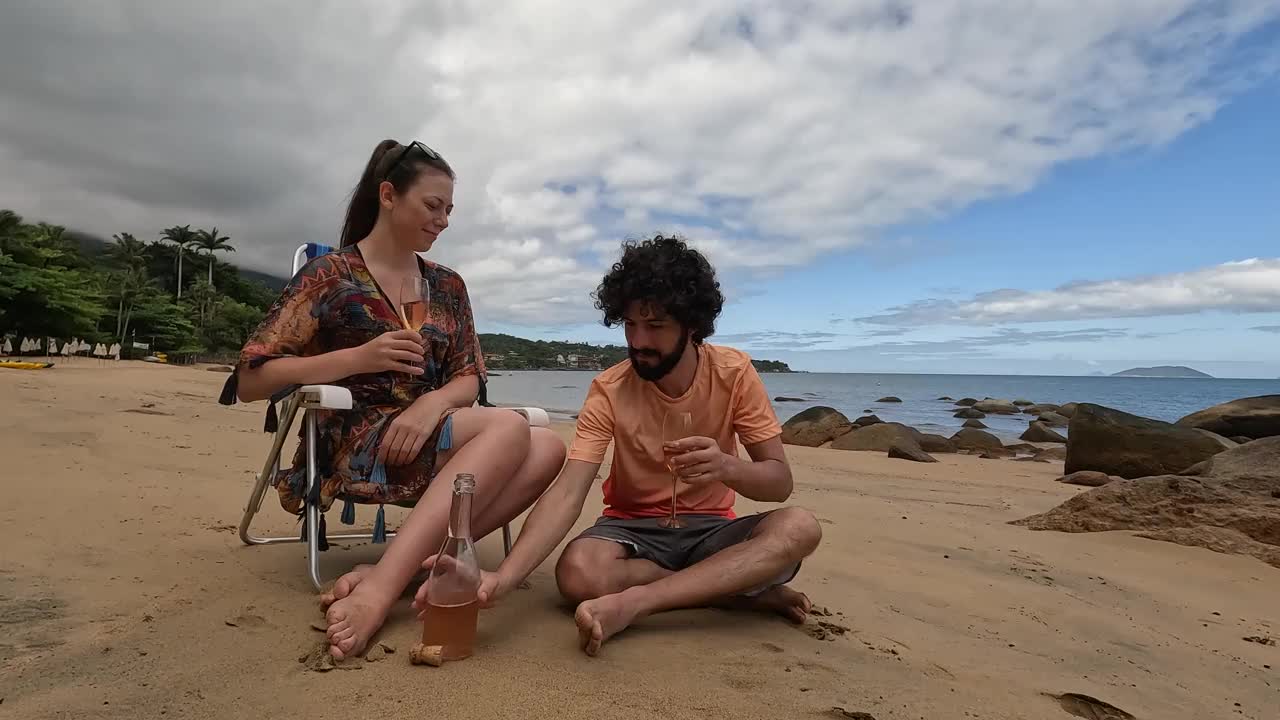 年轻的千禧夫妇在荒芜的海滩上庆祝新年视频下载