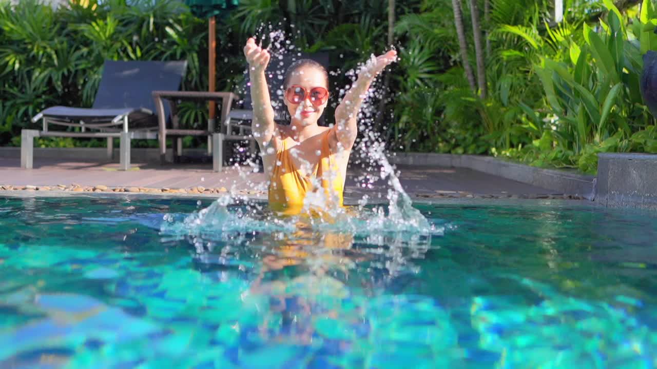 年轻的亚洲女性在户外游泳池放松快乐视频下载