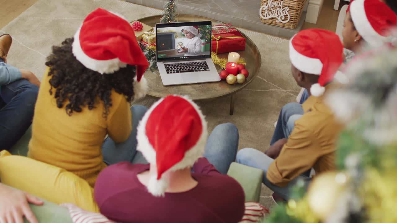 不同的家庭与圣诞帽使用笔记本电脑的圣诞视频电话与屏幕上的男孩视频下载