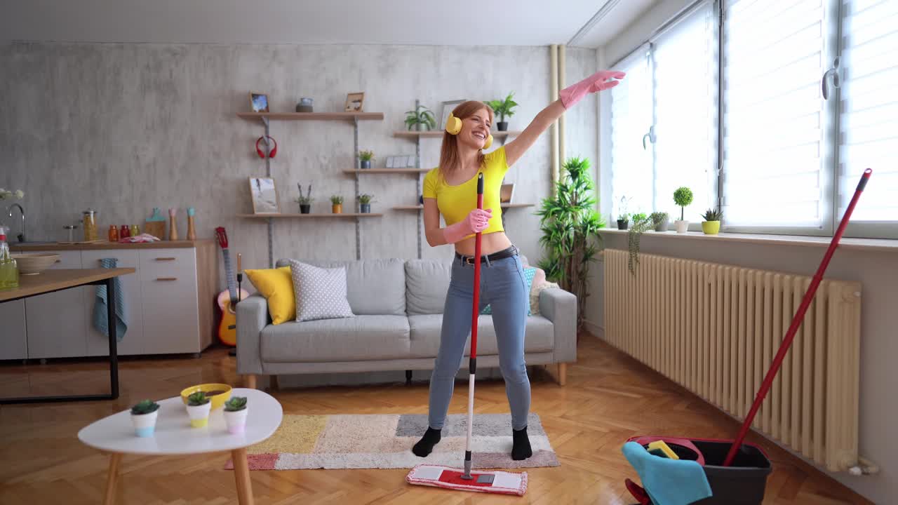 快乐的女人打扫房子和跳舞视频素材