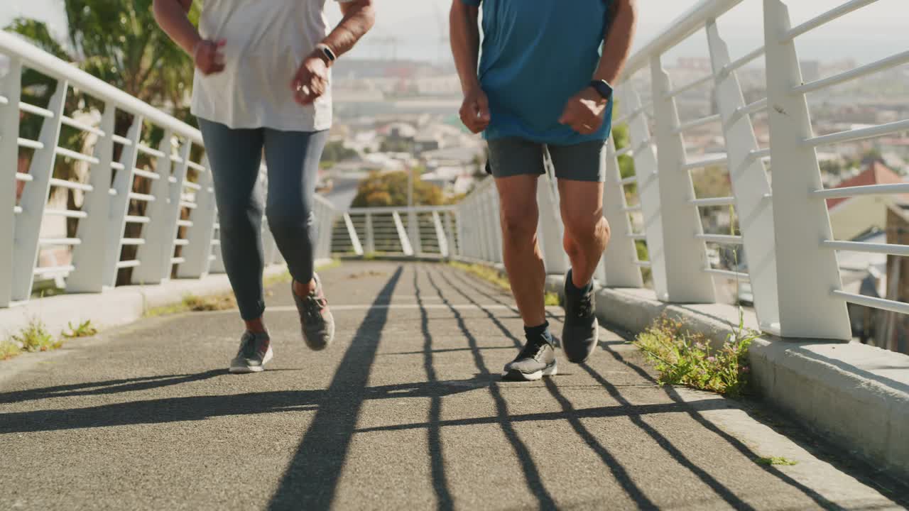 一个运动的高级夫妇享受他们的时间一起在城市跑步的4k视频镜头视频素材