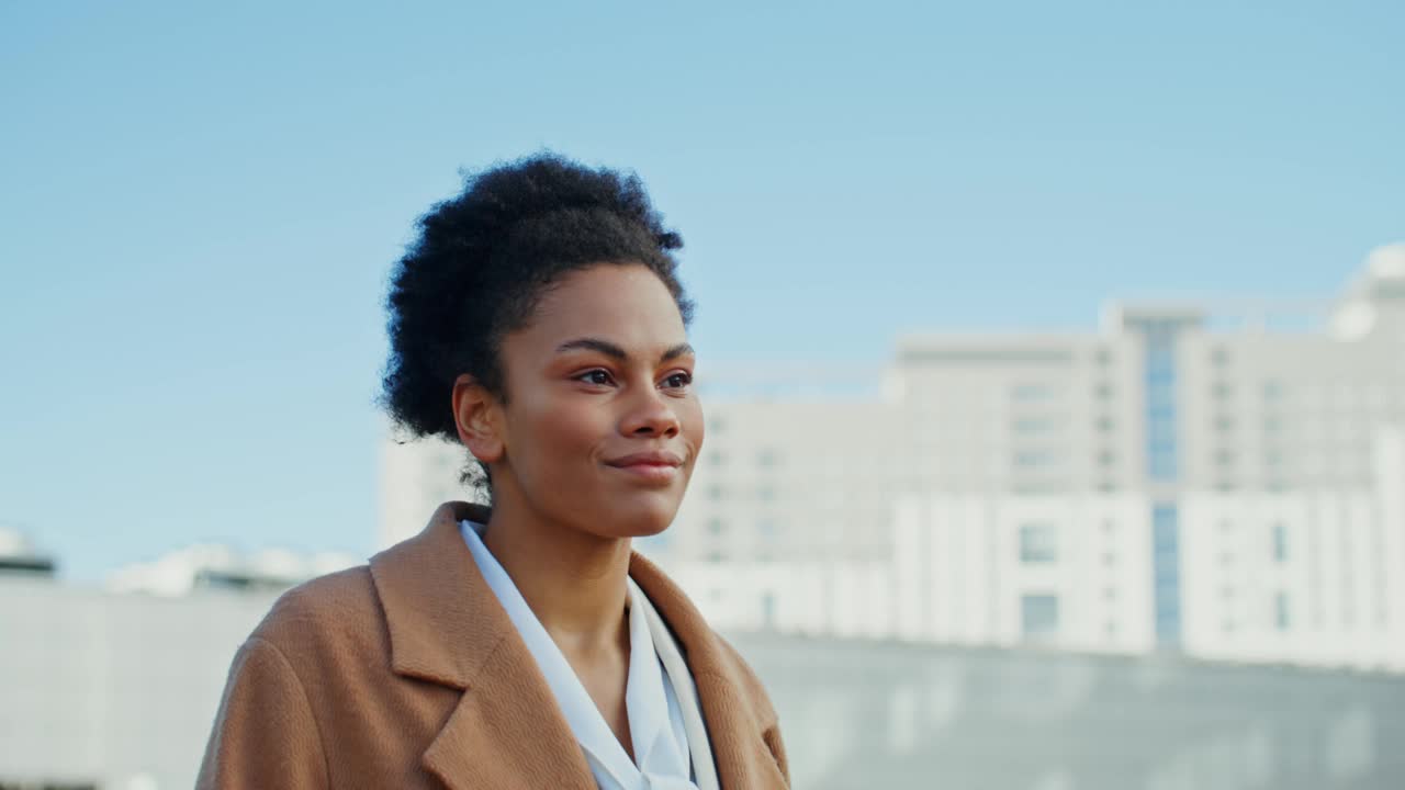 一位非裔美国妇女正微笑着走过市中心视频素材