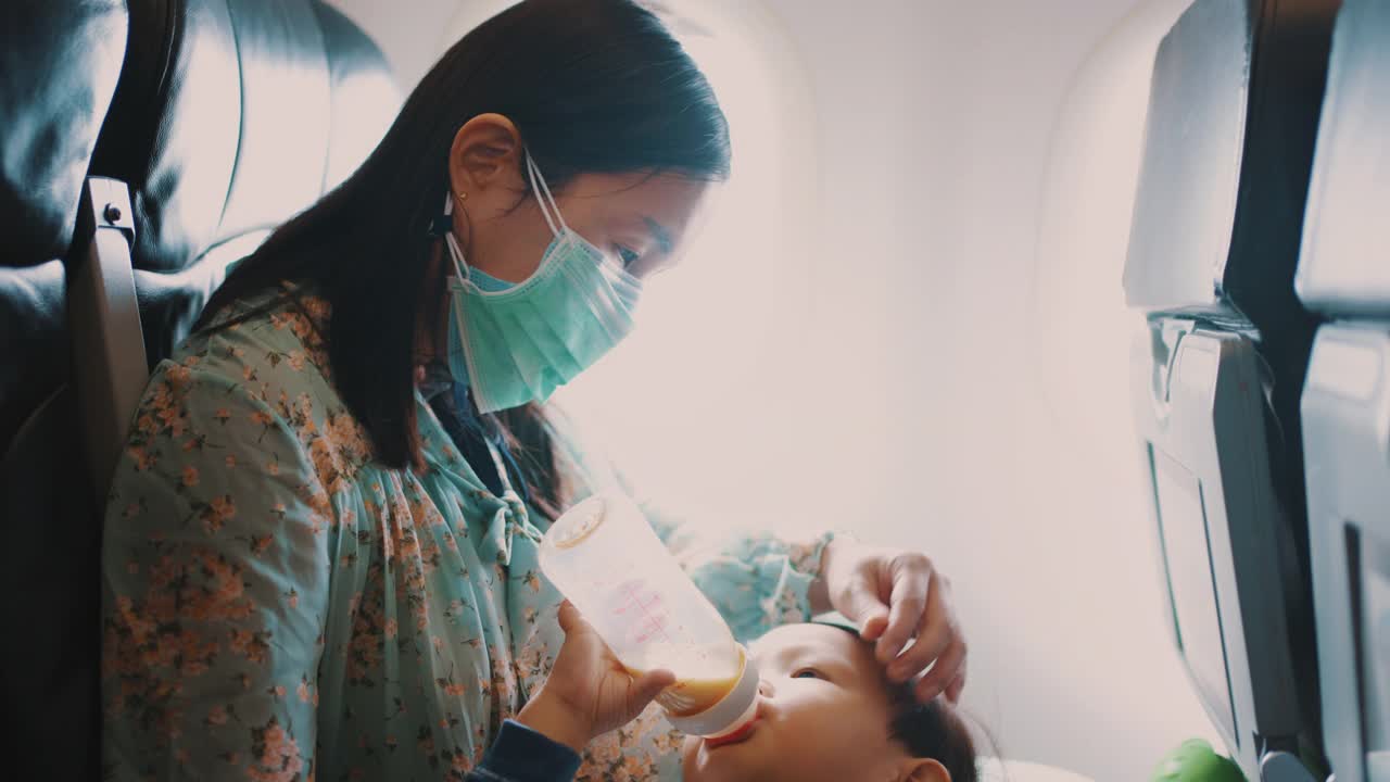 母亲在乘飞机旅行时喂儿子吃饭视频素材