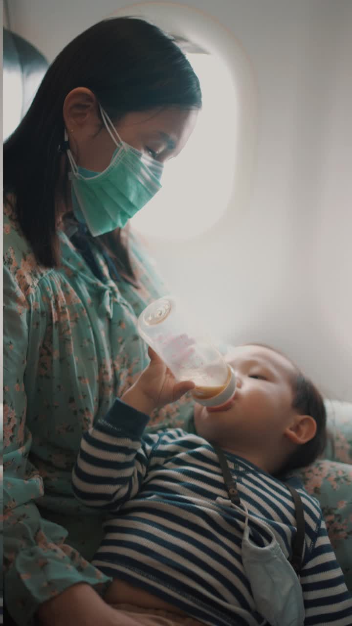 母亲在乘飞机旅行时喂儿子吃饭视频素材