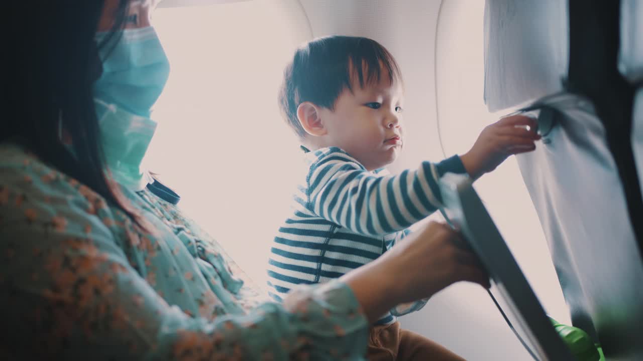 母亲和蹒跚学步的男孩在飞机上视频素材