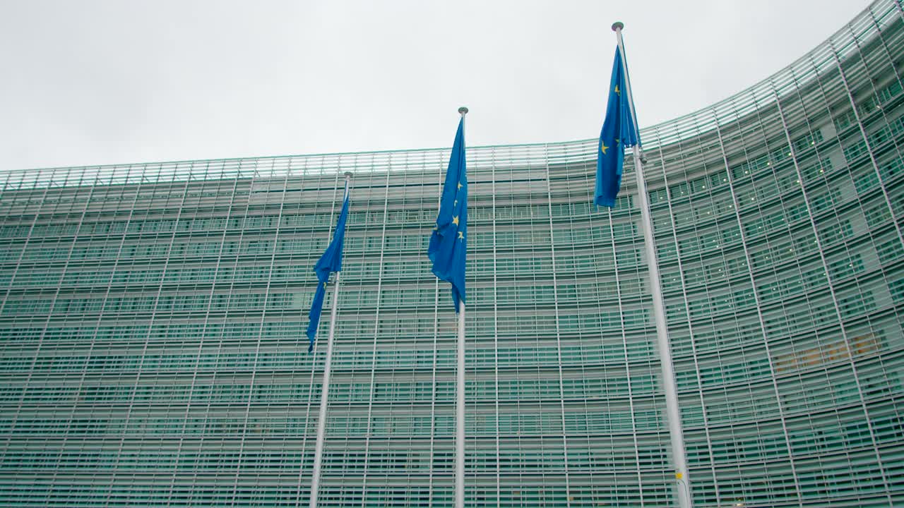 在比利时布鲁塞尔的欧盟委员会办公大楼附近挥舞着欧盟旗帜视频素材