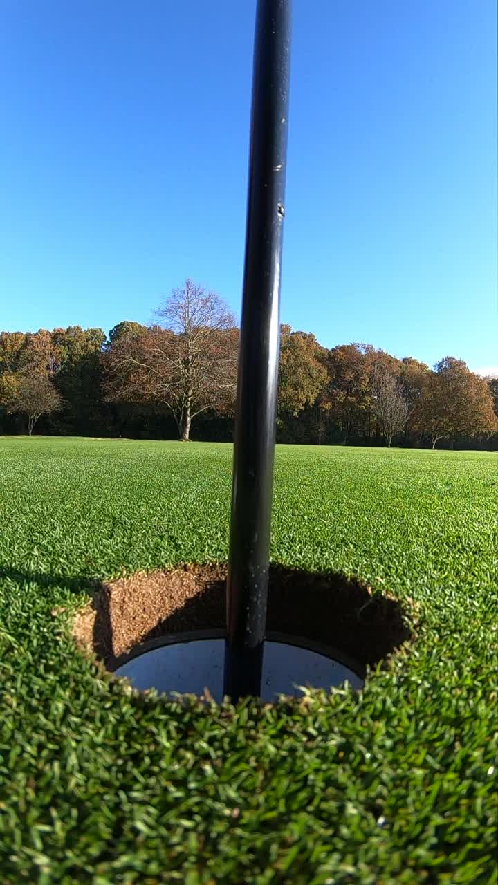 高尔夫球进入洞的极度特写慢动作。视频素材
