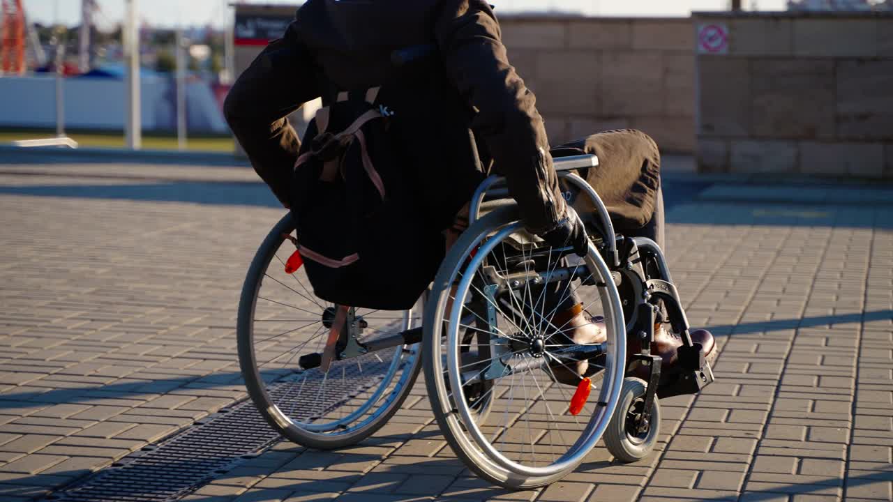 在现代城市的街道上，坐着手动轮椅的人走动，这是残疾人的一种设备视频下载