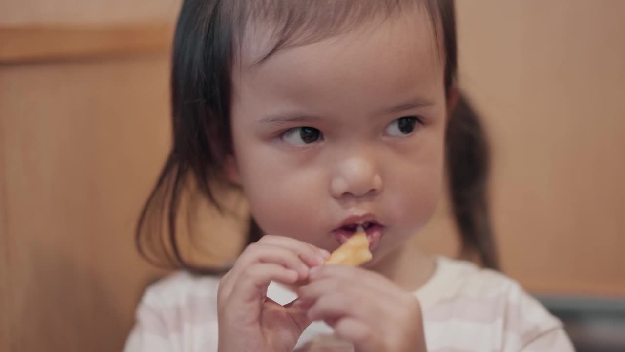亚洲小女孩在餐厅吃薯条的特写镜头视频素材