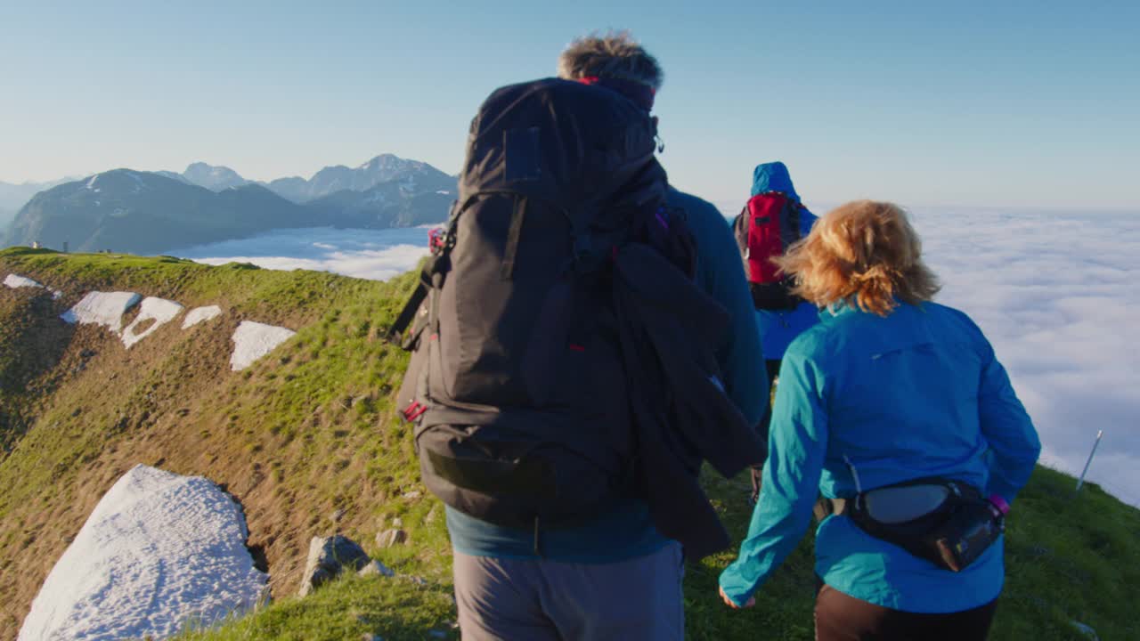 三个徒步旅行者在山脊上行走视频下载