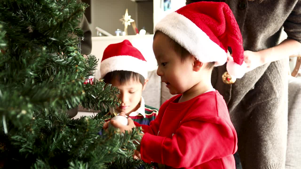一个男孩试图装饰圣诞树视频下载