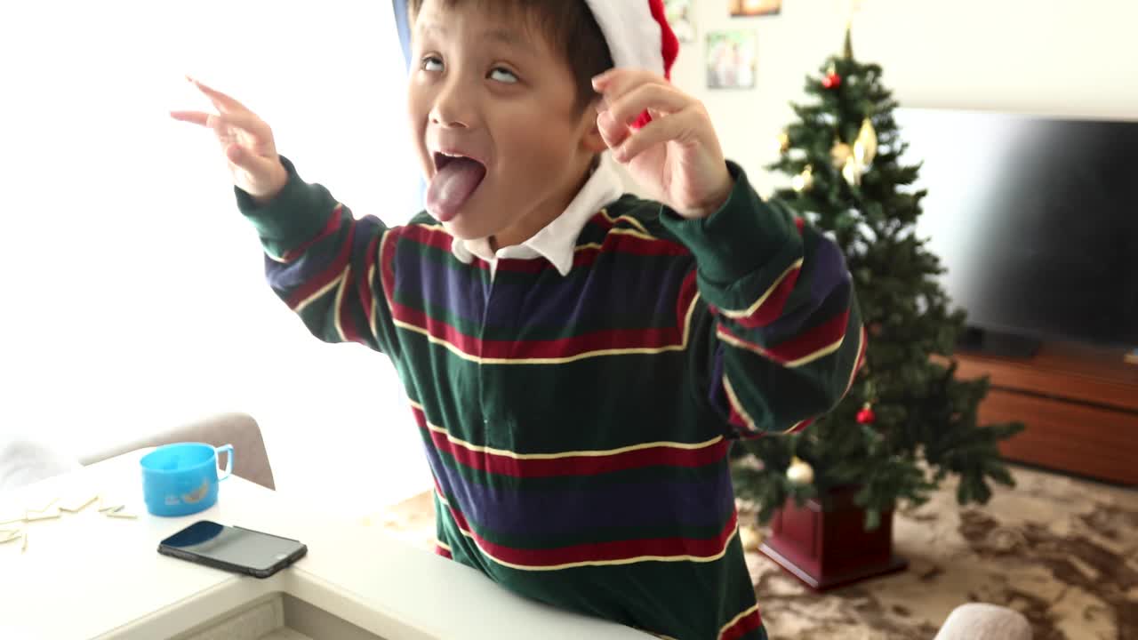一个戴着圣诞帽做鬼脸的男孩视频下载