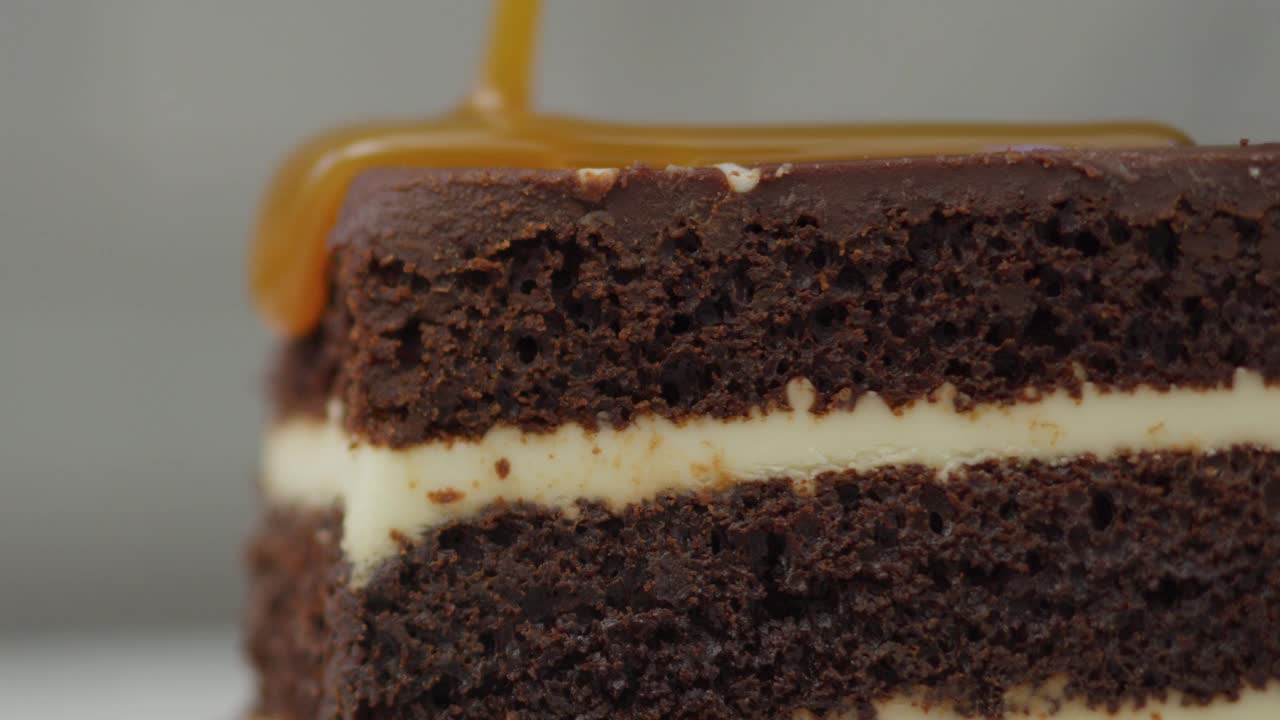 焦糖酱倒在巧克力甜点上。用RED 8K相机拍摄。视频素材