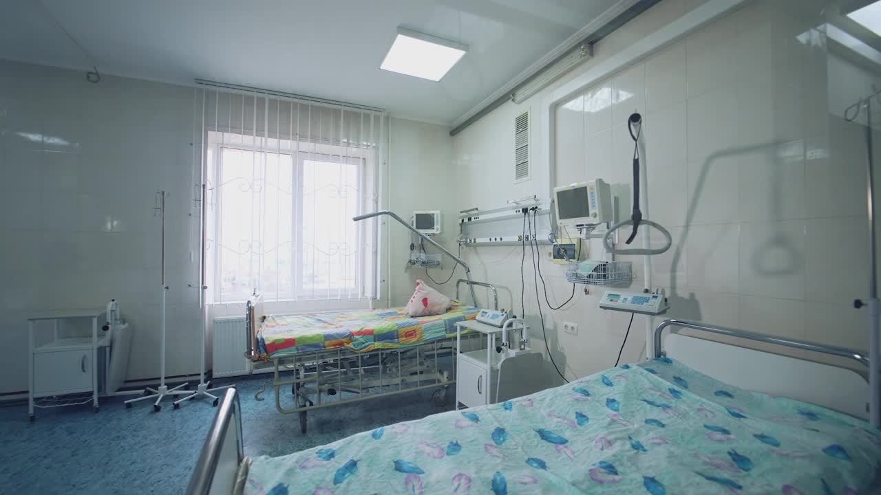配备医院病床的现代复苏室。病床附近有新设备的医疗病房。病床空着的病房透过窗户往病房内看。视频素材