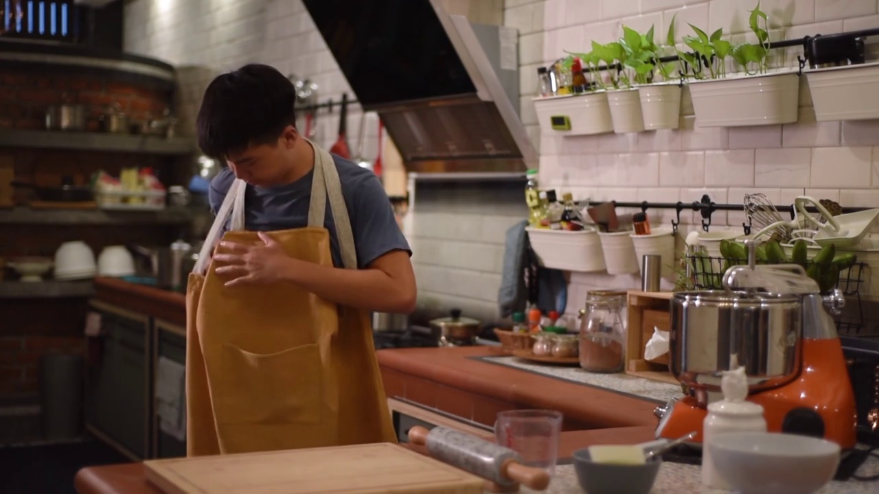 亚洲中国少年男孩面包师穿着围裙在厨房视频下载
