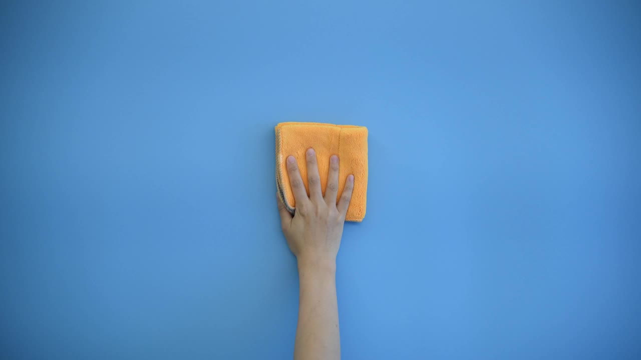 女人用抹布擦蓝色的墙视频购买