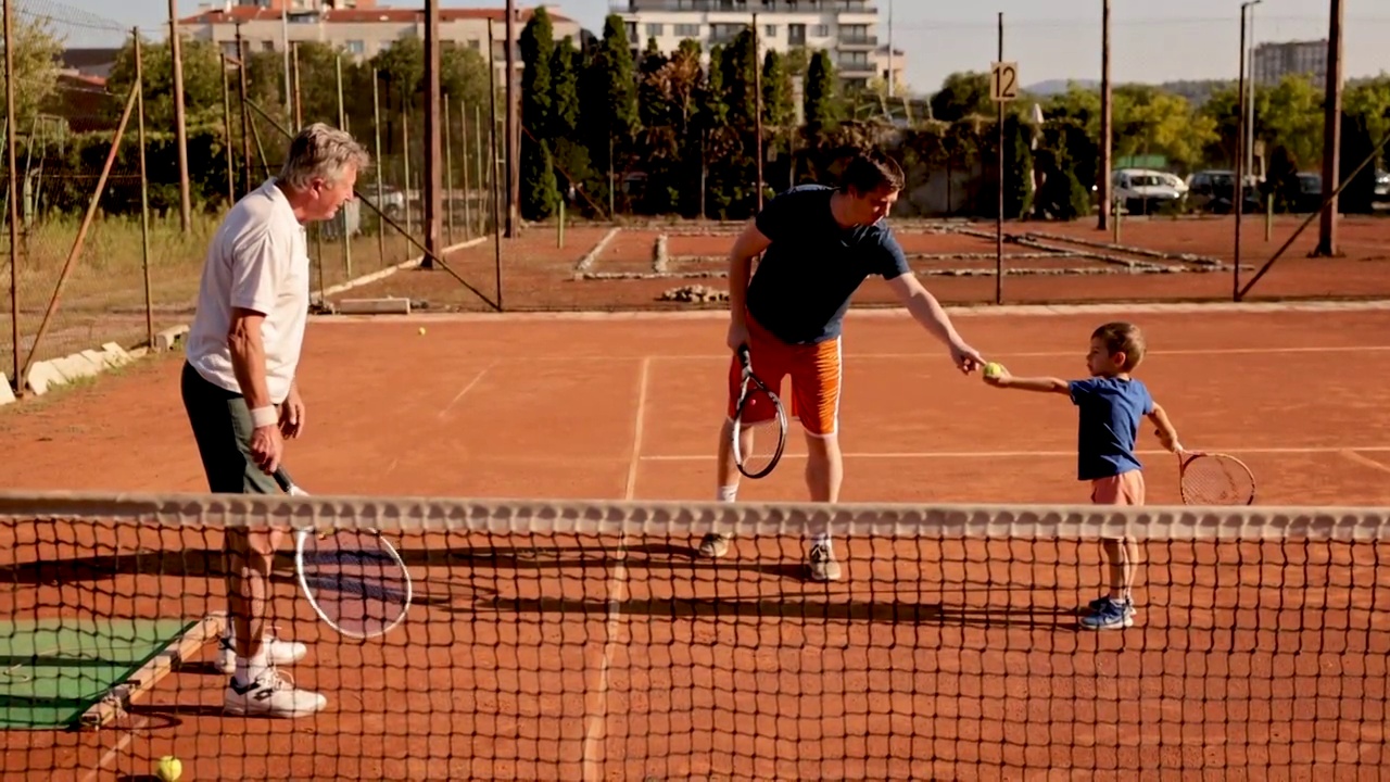一个好奇的男孩，在祖父和父亲的网球训练中，学习网球的基本知识视频下载