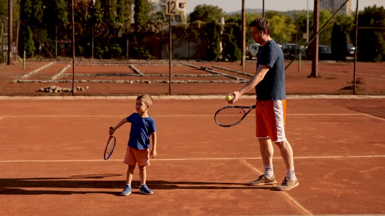 父亲学习他可爱的儿子，网球的基本知识，利用这段时间与儿子建立联系视频下载