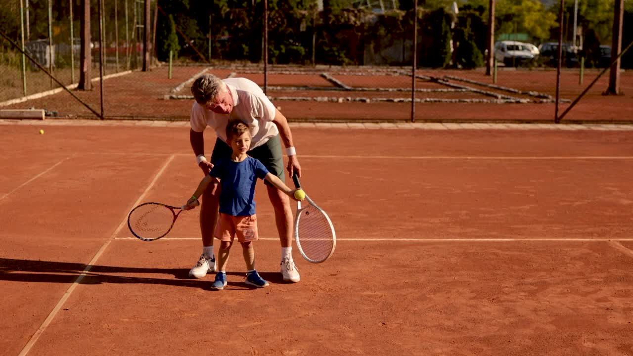 骄傲的爷爷，教他的孙子打网球视频下载
