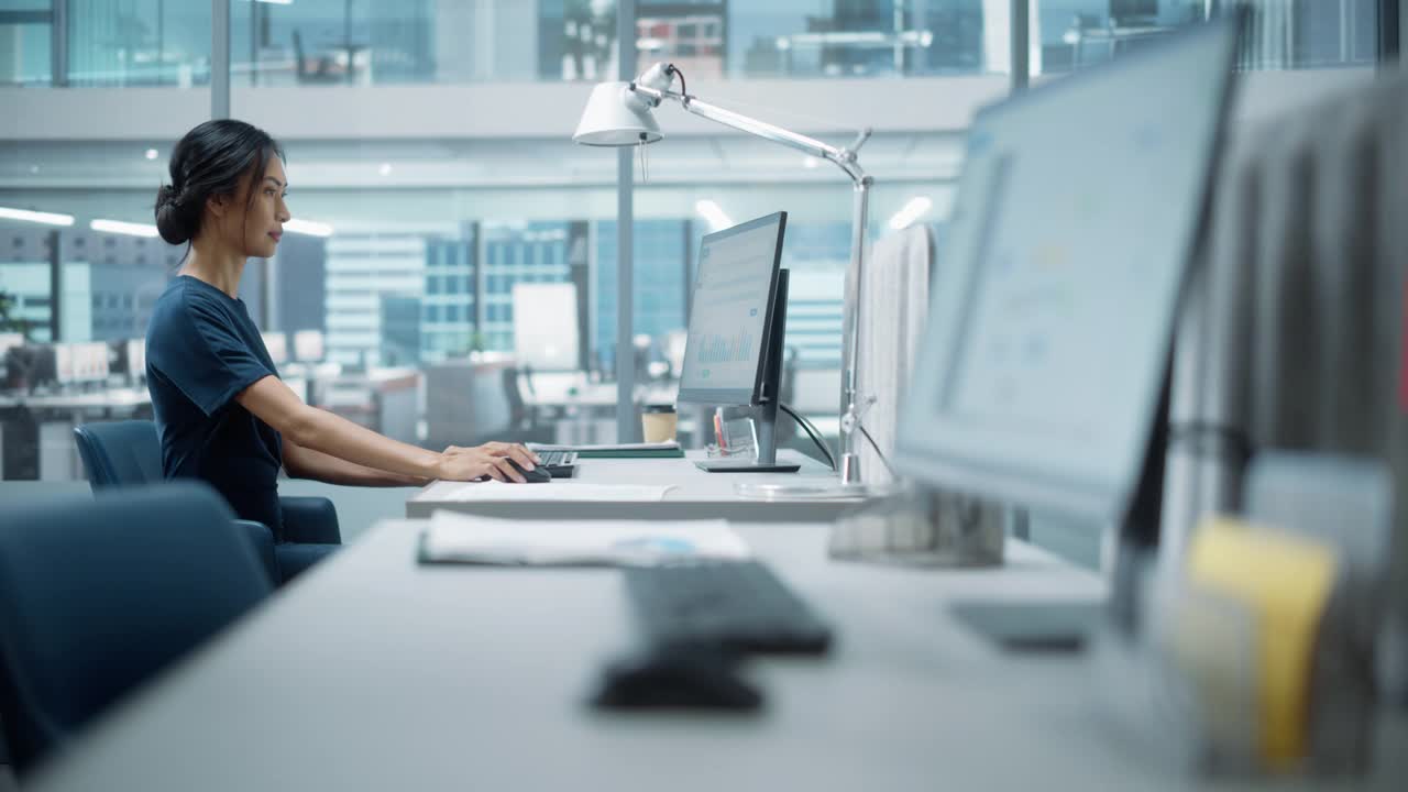在大多样化的公司办公室:美丽的亚洲经理肖像使用台式电脑，女商人管理公司运营，分析统计，商业数据，营销计划。视频下载