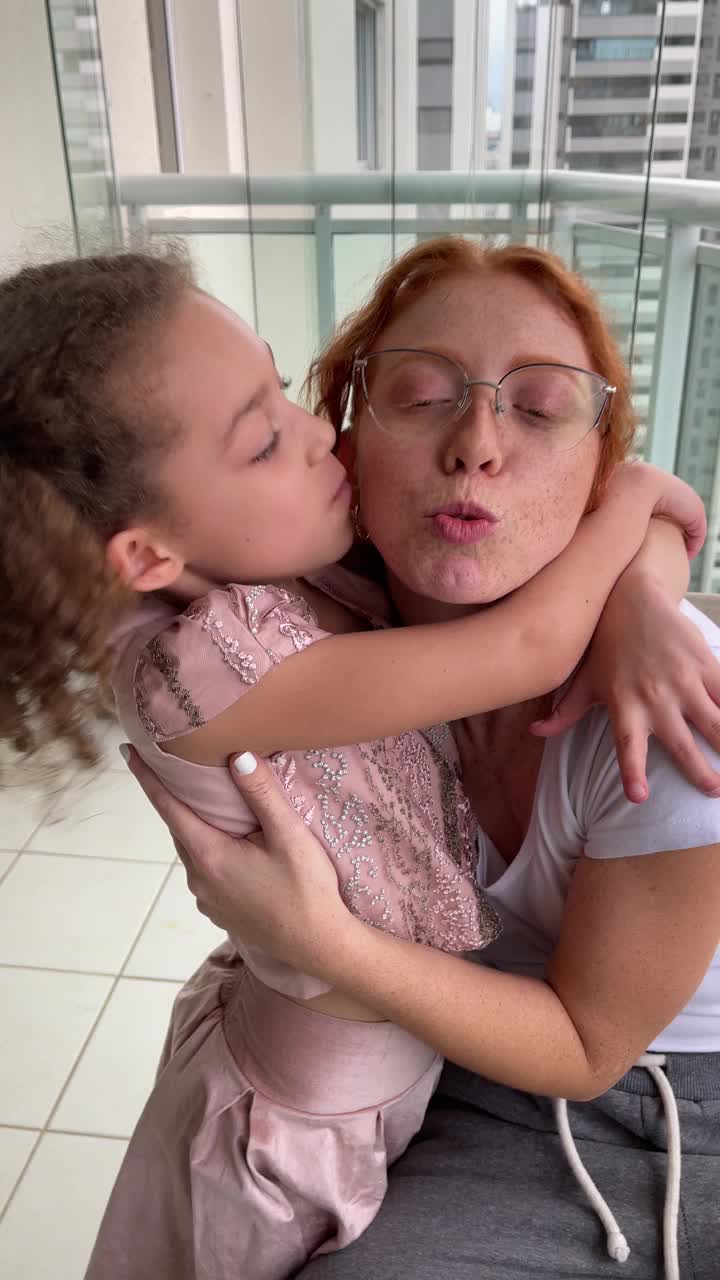 漂亮的红发年轻女子和她的小妹妹拥抱在一起。视频下载