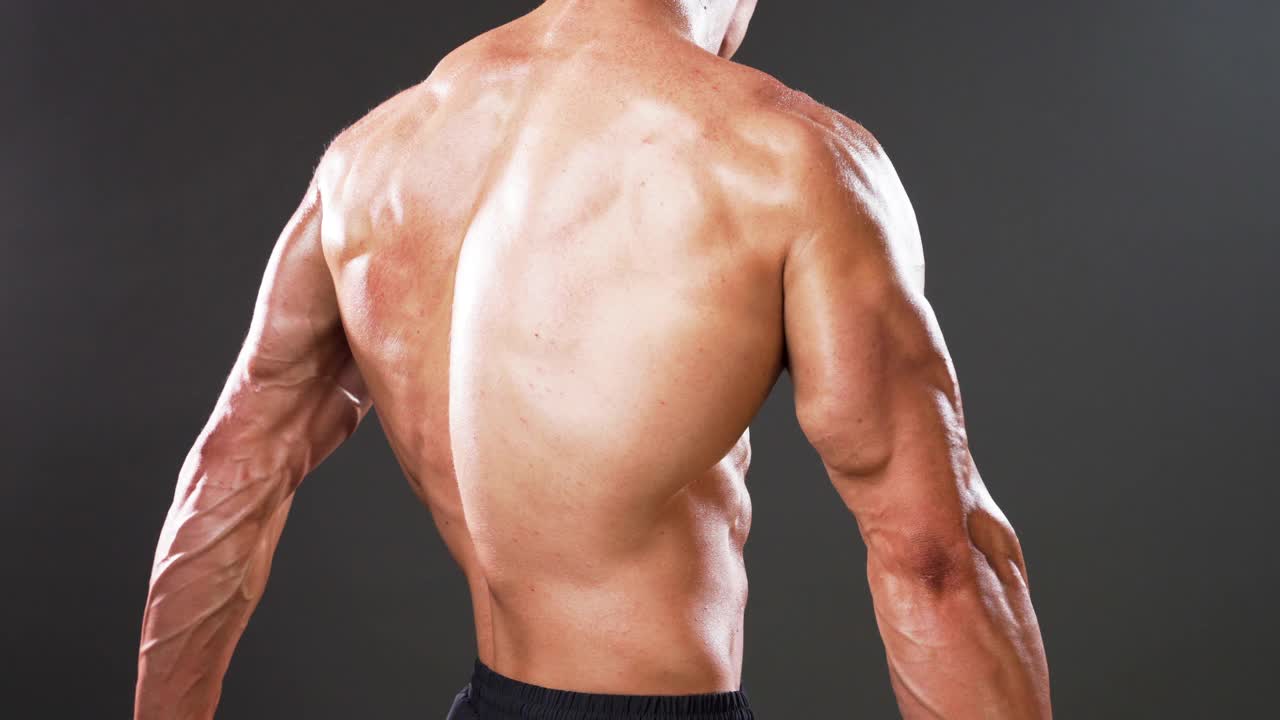 赤膊健美运动员肌肉男人弯曲他的手臂，胸部，和腹肌视频下载